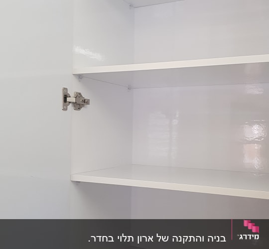 ארון לבן עם מדפים ודלתות עם צירים מתכתיים